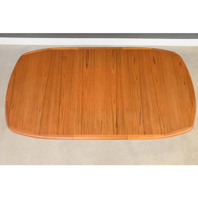 A mid century modern teak dining table with one 18.75” leaf and a pedestal base. Made in Canada. Professionally...