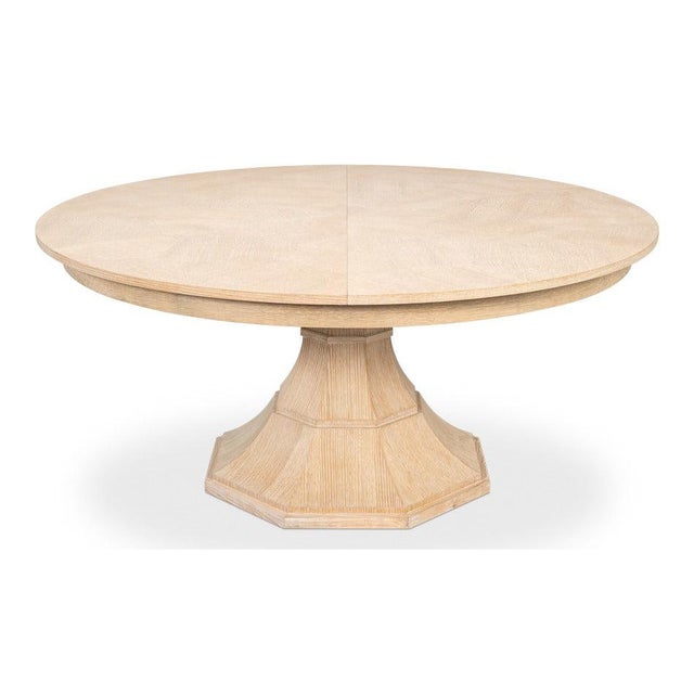 Pale bleached oak and a sculptural pedestal support a circular top that expands from 66 to 85 1/2 inches with self-storing...