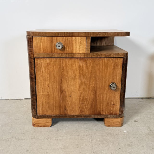 A beautiful set of two mirrored bedside tables in a distinct Art Deco and Streamline Moderne style from the 1950s. This...