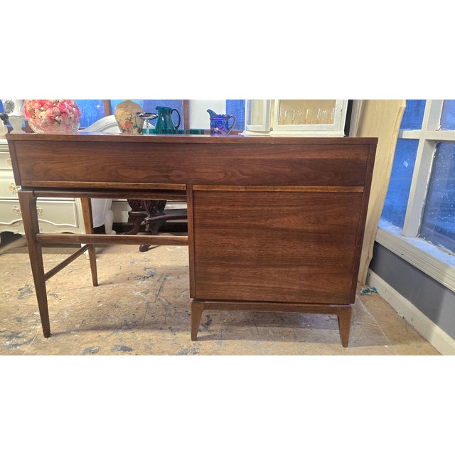 Mid Century Modern writing desk with drawers on one side. Made from beautiful walnut. Original brass hardware.. Maker Kent...