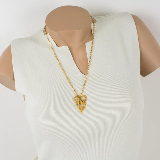 This stunning Christian Lacroix Paris pendant necklace features a stylized knitting lace design with gilded metal, all...
