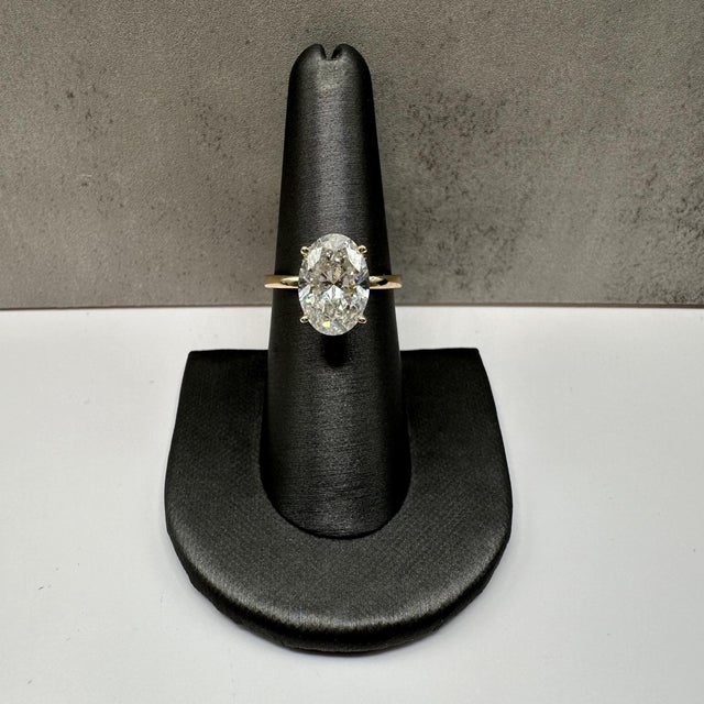 This gorgeous oval cut lab diamond engagement ring is crafted in polished 14kt yellow gold and features a stunning IGI...