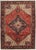 Vintage hand-knotted Persian Heriz wool rug with a red field centered by a bold geometric medallion in navy, ivory, and...