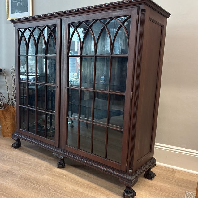 Gorgeous claw foot china cabinet/bookcase featuring gothic style paned glass doors. Excellent condition for age. Does have...