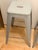 Set of three authentic Tolix Marais H65 counter-height stools in a soft grey-beige painted finish. An enduring French...