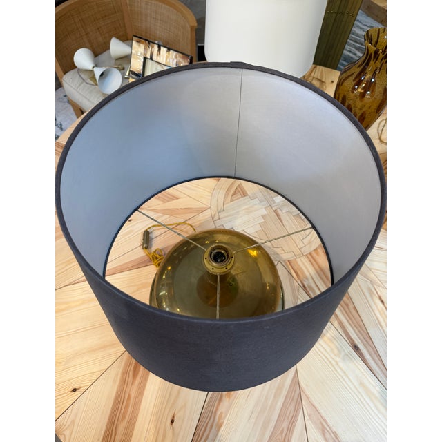 Elegant table lamp featuring a rounded brass body with stacked, domed forms and a warm, aged patina. Its sculptural base...