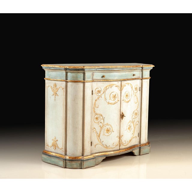 Handcrafted in Italy, this credenza features a softly curved front with one drawer and two locking doors. Hand-painted...
