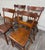 This is a gorgeous set of four antique American Country Farmhouse plank seat dining chairs, likely from 1880–1910....