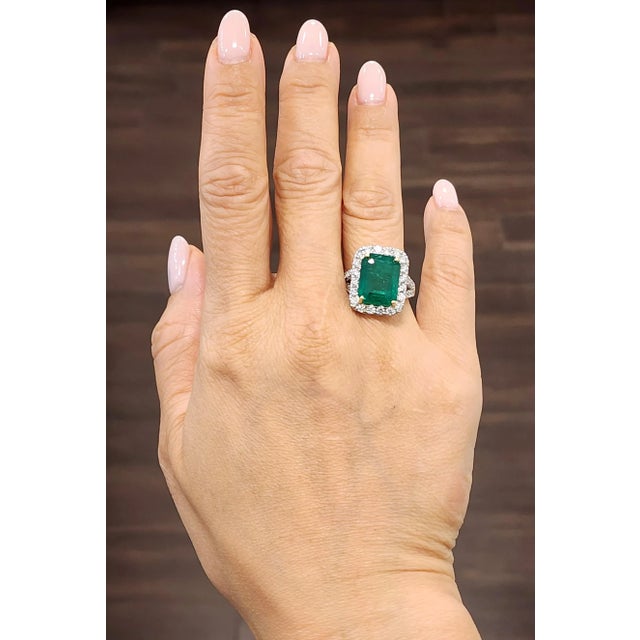 A breathtaking platinum cocktail ring featuring an 8.20-carat GIA certified Zambian emerald-cut emerald, radiating a rich...