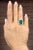 A breathtaking platinum cocktail ring featuring an 8.20-carat GIA certified Zambian emerald-cut emerald, radiating a rich...