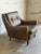 This lounge chair features a contoured frame with button-tufted backrest and sweeping armrests. Its inviting silhouette...