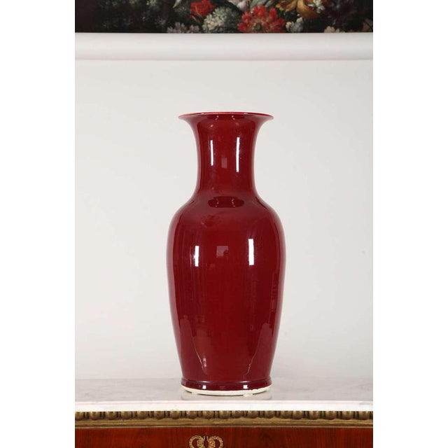 A pair of large sang-de-boeuf glazed vase, early 20th century. The baluster vessel rising from a lipped foot to a high-...