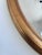 Elegant vintage oval mirror from Belgium, with beveled glass and a carved giltwood frame in a soft gold finish. Object:...