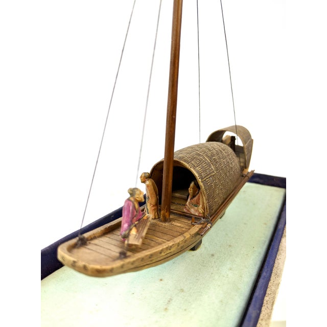 A miniature stone sailboat with people sitting inside. This is a vintage piece from the 1960’s and can be removed from the...