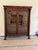 Antique Empire Cabinet A beautiful antique American Empire glass front bookcase with carved columns and lion paw feet....