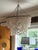 Glamorous contemporary shell and silver metal chandelier by Made Goods having a classical drapery vibe with overlapping...