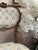 An elegant pair of early 19th century French salon chairs, distinguished by their shaped backs, finely carved aprons, and...