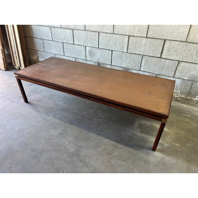 Striking Danish Mid-Century Modern coffee table, circa 1960s, crafted from richly figured solid rosewood and topped with a...