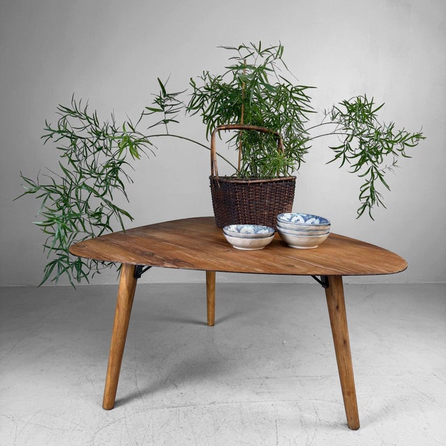 Vintage wooden coffee table, probably originating from Belgium. The table features an organically shaped top with soft,...