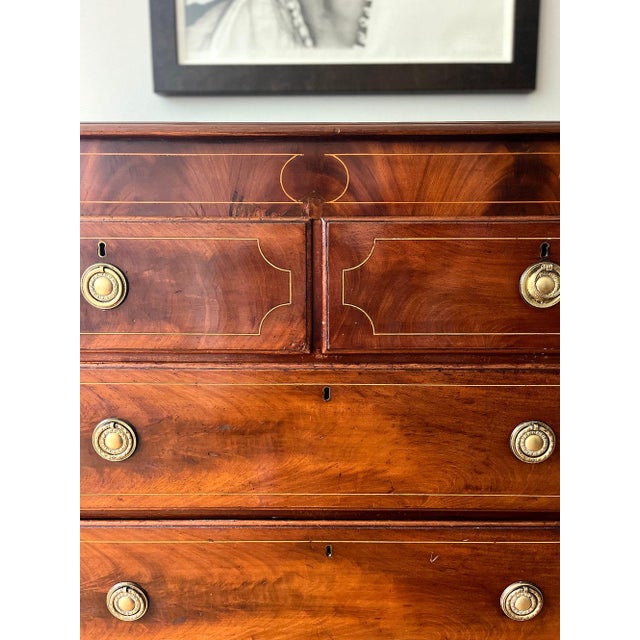 19th C George III Mahogany Chest with Four Drawers. The chest has flamed mahogany drawer fronts and banded top with string...