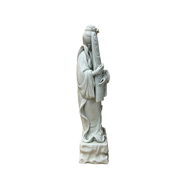 This exquisite celadon-glazed porcelain figurine depicts the revered Bodhisattva Guanyin standing in serene grace upon a...