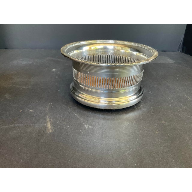 Vintage Reticulated Silver Plate Wood Wine Bottle Coaster in good estate condition. There is a spot where the silverplate...