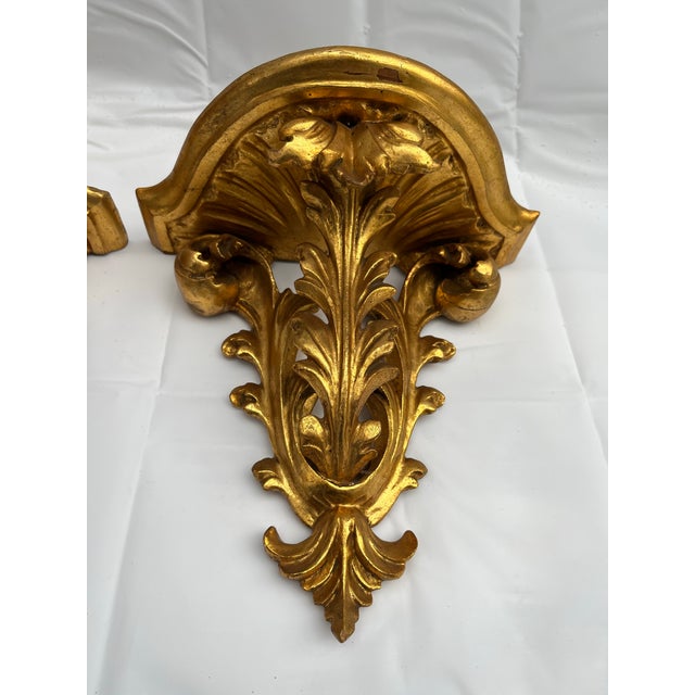 A magnificent pair of antique Italian carved wood wall brackets or shelves featuring acanthus leaf style supports and a...