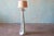 A heavy plaster floor lamp featuring a Trompe l'Oeil design that mimics the elegance of knotted, draped fabric. Finished...