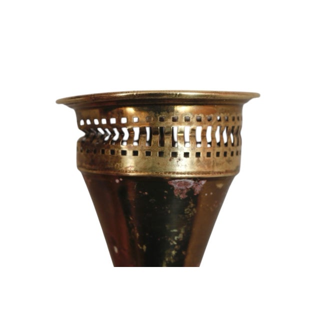 A pair of brass candlestick holders made by Duchin, circa 1950. Delicately pierced capitals sit above round bases pressed...