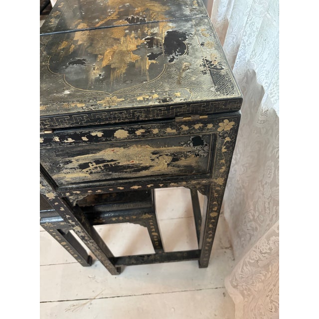 Elegant black lacquered chinoiserie vanity and stool set with richly decorated gilt scenic and floral motifs. Piece...