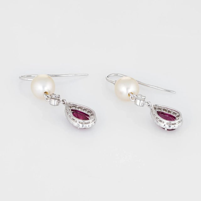 Elegant pair of estate pink tourmaline, diamond & cultured pearl earrings crafted in 18k white gold. Faceted pear cut pink...