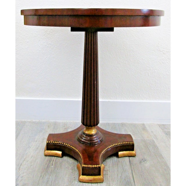 The Maitland-Smith Empire Pedestal Based Inlaid Marquetry Top Occasional Table is a stylish and elegant piece of furniture...