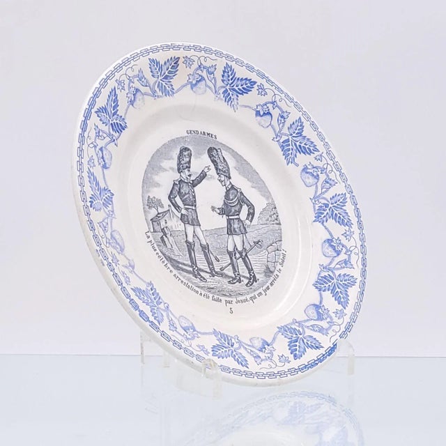A Creil blue and black bowl, France circa 1820. The center of the plate has two Gendarmes speaking to each other. The...