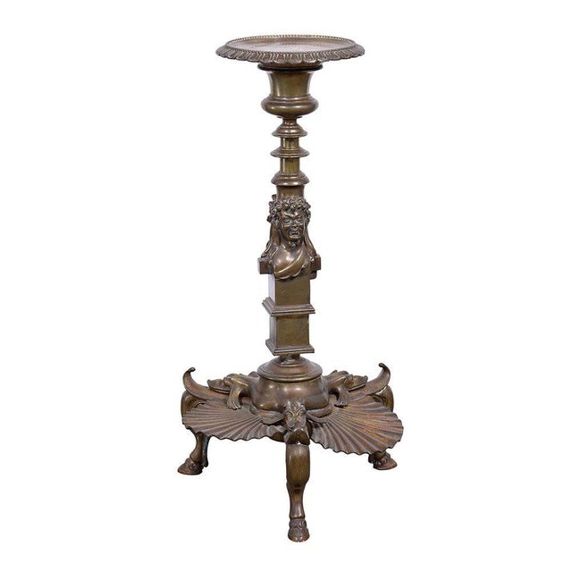 Antique bronze figural candle stand, circa 19th century. This antique candle stand is crafted in bronze with figural...