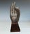 A bronze buddha hand sculpture mounted on a wood base. The last photo shows two nails in-between the wood and bronze hand....