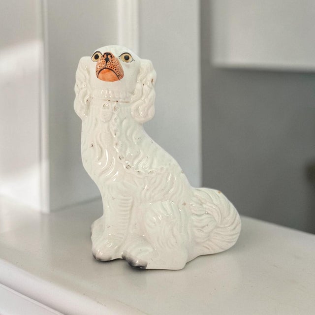 A mid-twentieth-century Staffordshire-style mantel figure modelled as a seated King Charles spaniel, circa 1940–1960, with...