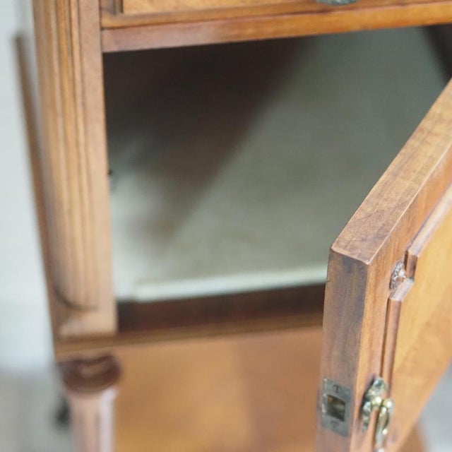 French bedside table in the Louis XVI style, made around 1900. The division into a closed body and an open base with a...