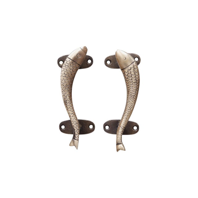 A pair of fish shaped cabinet pulls in brass with an antiqued finish. Cast with line details to show eyes, scales and...