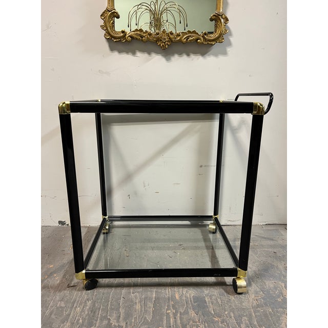 Bring polished cocktail-hour style to your room with this elegant black and gold-tone bar cart. Its glossy black frame,...