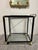 Bring polished cocktail-hour style to your room with this elegant black and gold-tone bar cart. Its glossy black frame,...