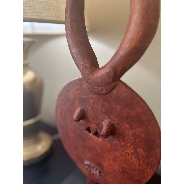 This is one of those pieces that immediately draws you in. The tribal mask form has such presence — the bold circular...