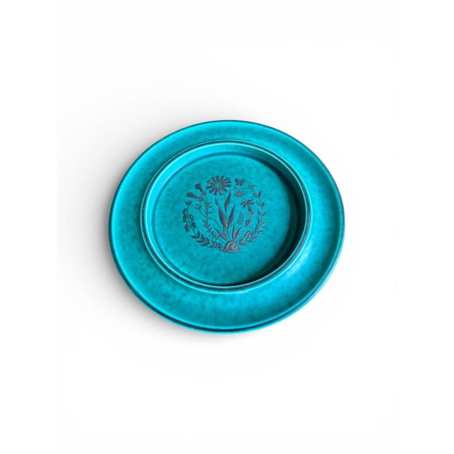 These stunning ceramic turquoise plates have applied designs of flowers and leafs and were designed by Wilhelm Kåge for...