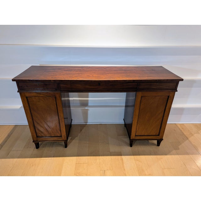 This, circa 1820, English regency mahogany sideboard stands on saber legs. Uppercase consists of solid mahogany and...