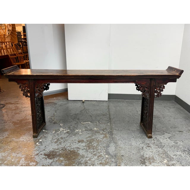 Design Plus Gallery presents an Antique Chinese Carved Wood Console Table. This elongated console showcases traditional...