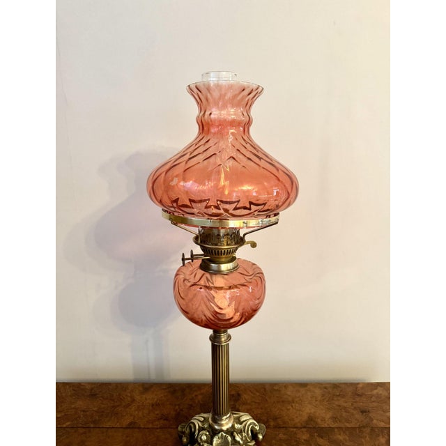 Fine quality antique Edwardian cranberry glass and brass oil lamp, having a quality antique Edwardian oil lamp with the...