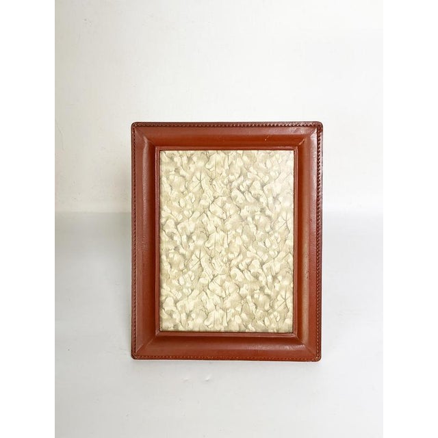 The photo is not provided. An elegant brown leather-covered photo frame, characteristic of refined decorative accessories...