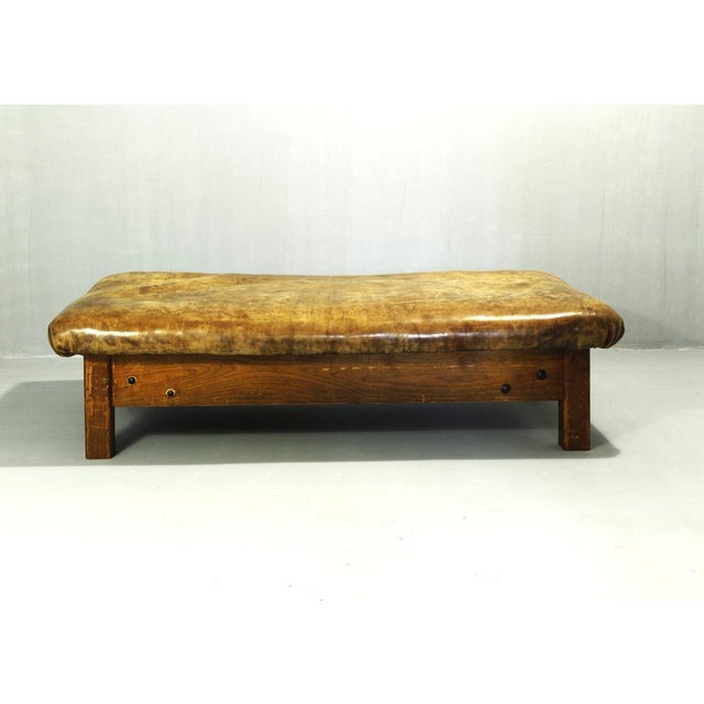 A beautifully weathered leather table, made of thick cowhide on an ash wood base. A gorgeous patina