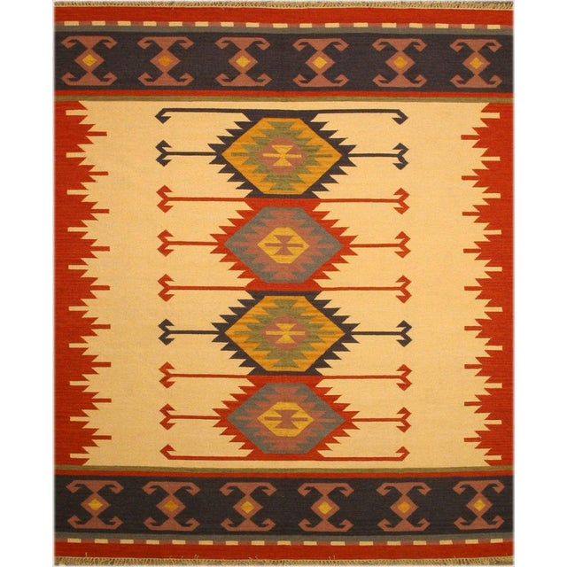 A handwoven wool kilim, made in India and measuring 9' x 12'. Kilims carry no pile — the pattern is woven through the...