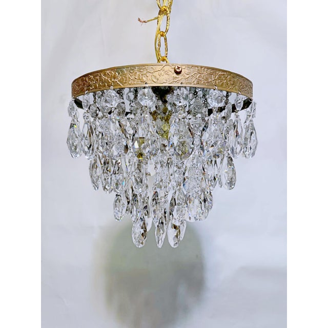Introduce romance and vintage texture to your home with this enchanting mid-century tiered brass crystal chandelier. This...
