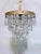 Introduce romance and vintage texture to your home with this enchanting mid-century tiered brass crystal chandelier. This...